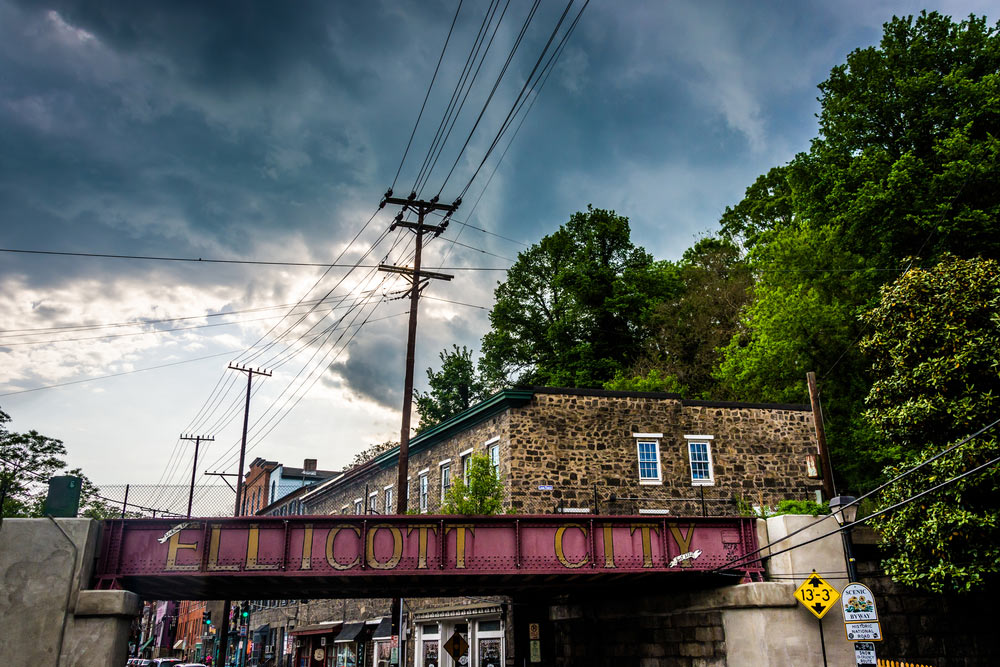 Image of the famous Ellicott City sign with stormy sky above